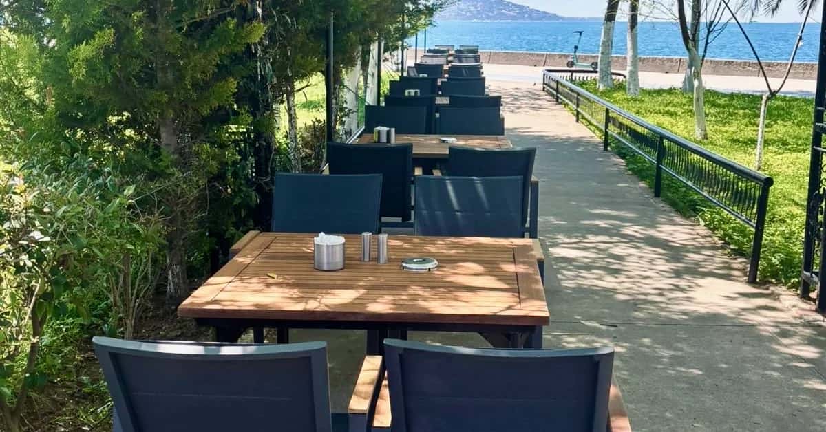 Tables in the shade of the trees at Maltepe, with the Princes' Islands in view